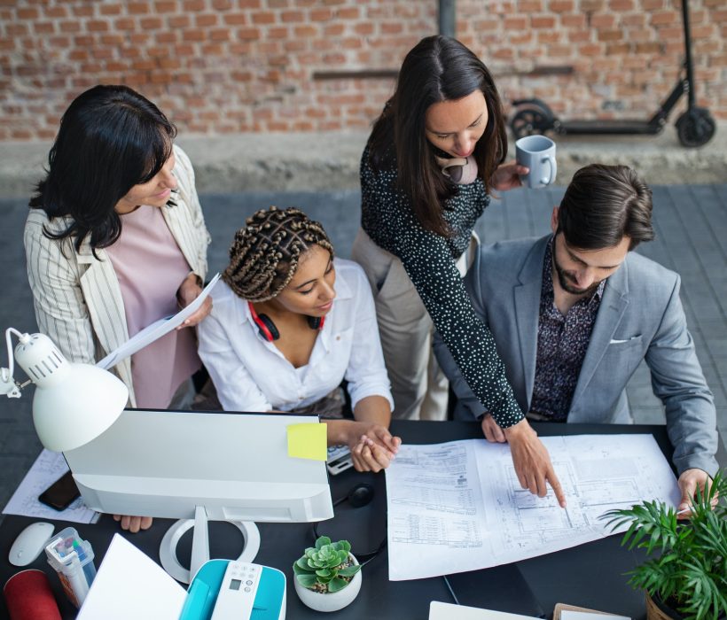 top-view-of-young-and-old-architects-sitting-and-working-at-desk-in-office-cooperation-concept.jpg